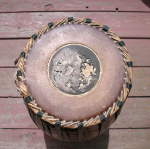 Badly damaged tuning paste on the treble drum head of a mridangam.