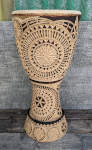 A beautifully carved djembe shell with intricate designs carved all around.