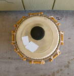 Damaged tabla bayan drum head with patches.